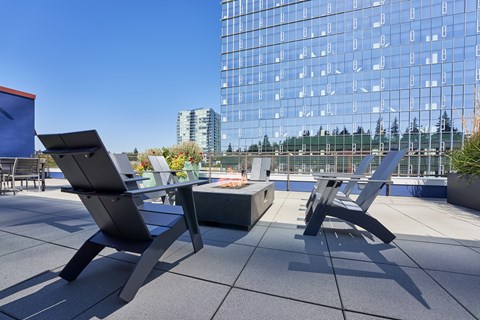 a patio with two chairs and a table on a rooftop